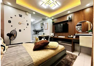 a living room with a large clock on the wall at KL Tower Makati near Greenbelt with free access to gym, sauna & 100Mbps Wi-fi in Manila