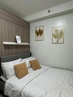 a bedroom with a large white bed with two pillows at Shore 2 Condo unit near MOA in Manila