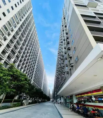 two tall buildings are next to a street in a city at Shore 2 Condo unit near MOA in Manila