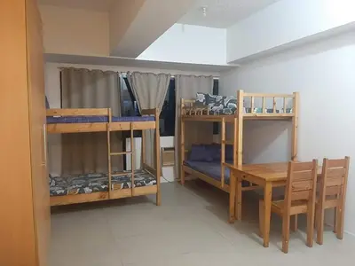 a room with bunk beds and a table and a desk at Male Bunkbed Room Sharing in Manila