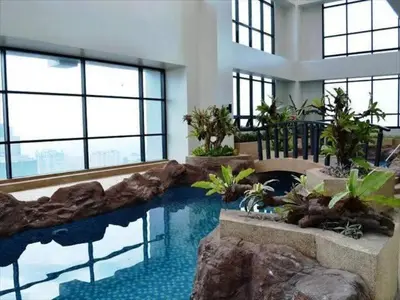 a swimming pool in a building with a rock wall at Male Bunkbed Room Sharing in Manila