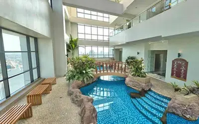 a large swimming pool in a building with benches at Male Bunkbed Room Sharing in Manila