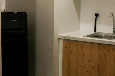 a kitchen with a sink and a black refrigerator at Serenity Suites: Your tranquil gateway! in Biñan