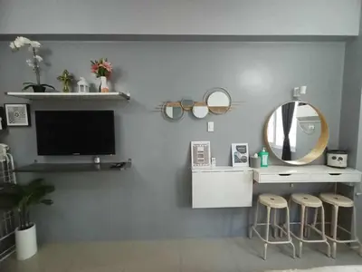 a living room with a mirror and a tv and stools at Homestay Manila Mall of Asia Shore Residences at TresMarias' in Manila