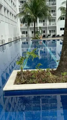 a swimming pool in front of a large building at Homestay Manila Mall of Asia Shore Residences at TresMarias' in Manila