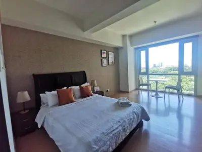 a bedroom with a large bed and a large window at Caleze Properties AVANT at the Fort BGC Studio in Manila