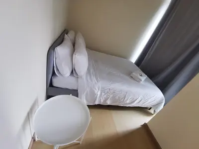 a bed with white sheets and a lamp in a room at Caleze Properties AVANT at the Fort BGC Studio in Manila