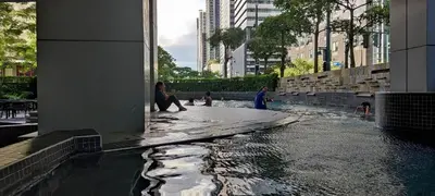 a woman sitting on the edge of a water fountain at Caleze Properties AVANT at the Fort BGC Studio in Manila