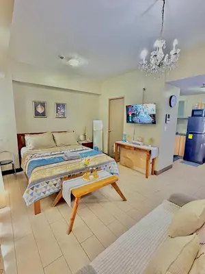 a bedroom with a large bed and a table at Condo in Newport City Pasay near NAIA T3 AIRPORT MANILA in Manila