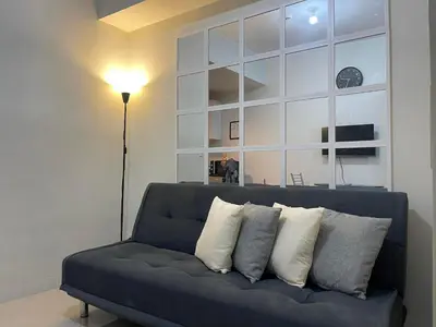 a blue couch with pillows on it in a living room at Jazz Residences Makati City by darpm in Manila