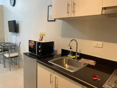 a kitchen with a sink and a microwave at Jazz Residences Makati City by darpm in Manila