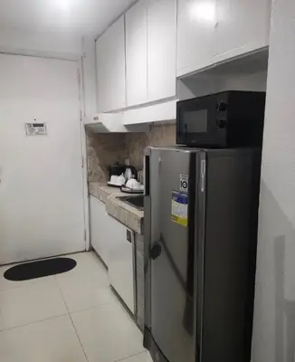 a kitchen with a stainless steel refrigerator and a microwave at Citadel Inn in Manila