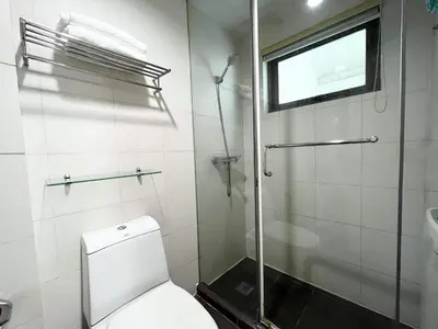 a bathroom with a toilet and a shower and a window at KL Tower Makati near AIM, Greenbelt 90mbps WIFI in Manila