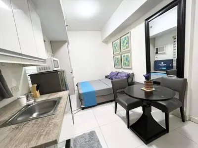 a small kitchen with a table and a bed in a room at KL Tower Makati near AIM, Greenbelt 90mbps WIFI in Manila