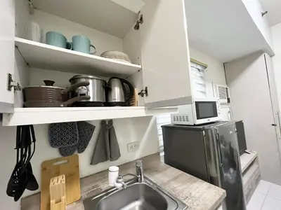 a kitchen with a sink and a microwave at KL Tower Makati near AIM, Greenbelt 90mbps WIFI in Manila