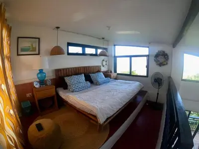 a bedroom with a bed with blue pillows on it at Dicimulacion Staycation House in Angono
