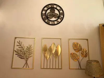 four framed leaves and a clock on a wall at Dicimulacion Staycation House in Angono