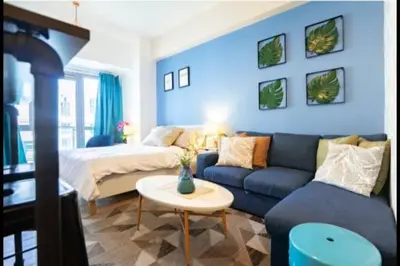 a blue living room with a couch and a bed at Cozy Studio Flat Near Airport in Manila