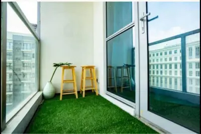 a balcony with green grass and a table on it at Cozy Studio Flat Near Airport in Manila