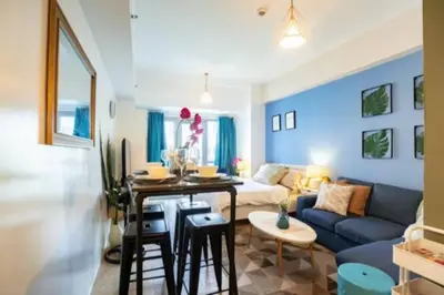 a blue living room with a couch and a table at Cozy Studio Flat Near Airport in Manila
