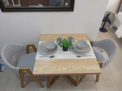 a wooden table with plates and a plant on it at Pasay Staycation with Parking Space in 150 Newport Boulevard near Resort World & NAIA T3 in Manila