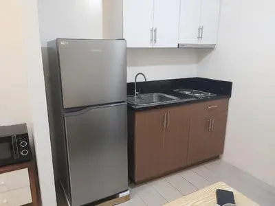 a kitchen with a stainless steel refrigerator and a sink at Pasay Staycation with Parking Space in 150 Newport Boulevard near Resort World & NAIA T3 in Manila