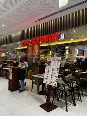 a restaurant with a sign that says savory and tables and chairs at Comfy Condo near BGC, Makati and Naia in Manila