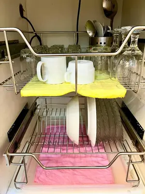 a shelf in a kitchen with dishes and utensils at Comfy Condo near BGC, Makati and Naia in Manila