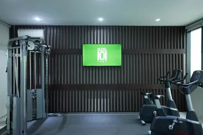 a gym with tread machines and a television on the wall at Hotel101 - Fort in Manila