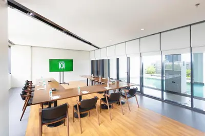 a conference room with tables and chairs and a green screen at Hotel101 - Fort in Manila