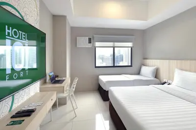 a hotel room with two beds and a tv at Hotel101 - Fort in Manila