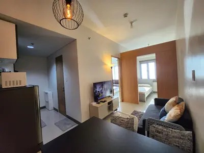 a living room with a couch and a table in a room at Bloom Residences Condo 2Br in Manila
