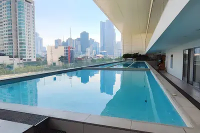 a large swimming pool with a view of the city at Aveline Suites Cozy Skyline View ACQUA Private Residences near Rockwell Makati in Manila