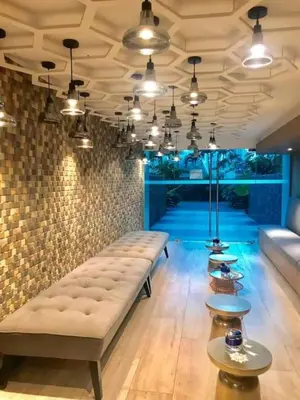 a living room with a couch and tables and lights at Aveline Suites Cozy Skyline View ACQUA Private Residences near Rockwell Makati in Manila