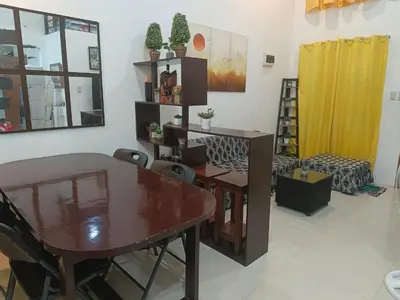a living room with a table and a dining room at Misty Hills Guesthouse Amadeo - Tagaytay in Amadeo
