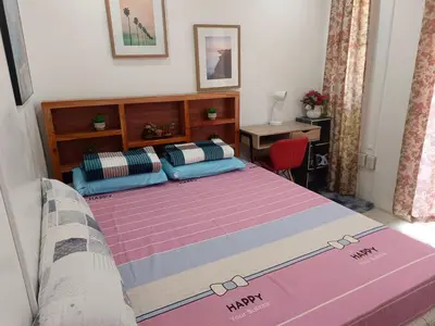 a bedroom with a large bed with a purple blanket at Misty Hills Guesthouse Amadeo - Tagaytay in Amadeo