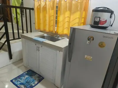 a small kitchen with a sink and a refrigerator at Misty Hills Guesthouse Amadeo - Tagaytay in Amadeo