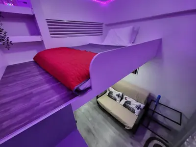 a purple bedroom with a bed and a stairway to it at Loft Suite in Chateau Elysee near Airport in Manila