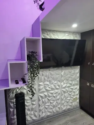 a purple wall with a tv and a plant at Loft Suite in Chateau Elysee near Airport in Manila