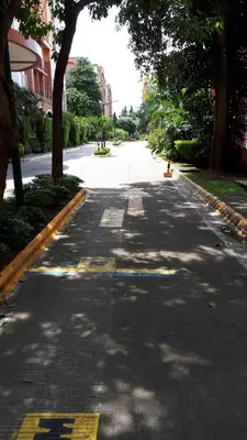 an empty street with trees on the sides of the road at Loft Suite in Chateau Elysee near Airport in Manila