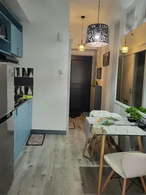 a kitchen and dining room with a table and chairs at Loft Suite in Chateau Elysee near Airport in Manila
