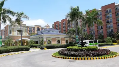 a street in a city with palm trees and a building at Loft Suite in Chateau Elysee near Airport in Manila