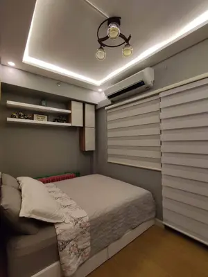a bedroom with a bed in a room with blinds at Maicozy condo in Manila