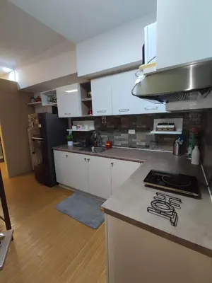 a kitchen with white cabinets and a counter top at Maicozy condo in Manila