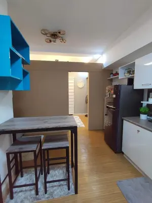 a kitchen with a table and chairs and a refrigerator at Maicozy condo in Manila