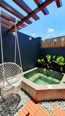 a patio with a swing and a swimming pool at The Farm Shack by SMS Hospitality in Amadeo