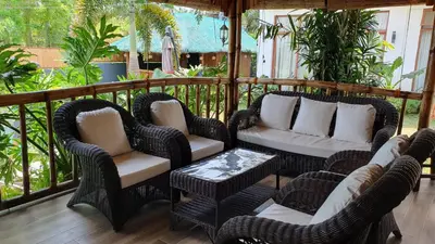 a porch with wicker chairs and a table at The Farm Shack by SMS Hospitality in Amadeo