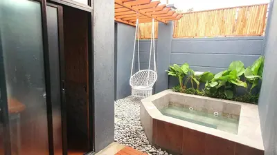 a hot tub in a garden with a swing at The Farm Shack by SMS Hospitality in Amadeo