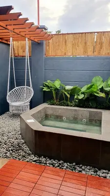 a hot tub in a garden with a swing at The Farm Shack by SMS Hospitality in Amadeo