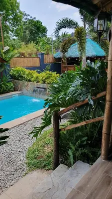 a swimming pool in a garden with a wooden bench at The Farm Shack by SMS Hospitality in Amadeo